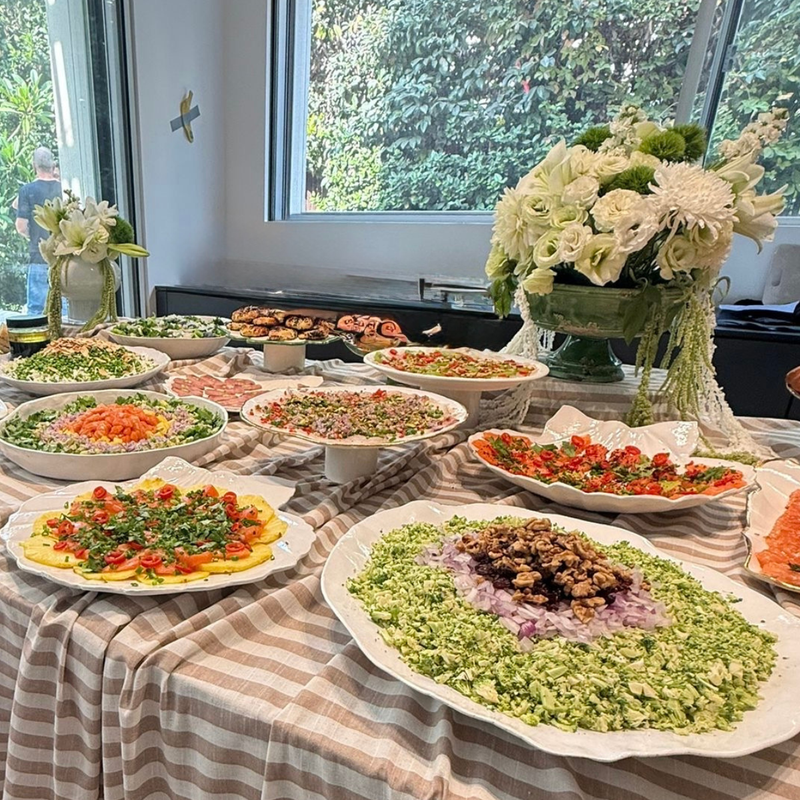 שולחן בופה מעוצב להשכרה בסגנון טבע אלגנטי ירוק לבן עם כלי הגשה לאירוח נרות ופרחים