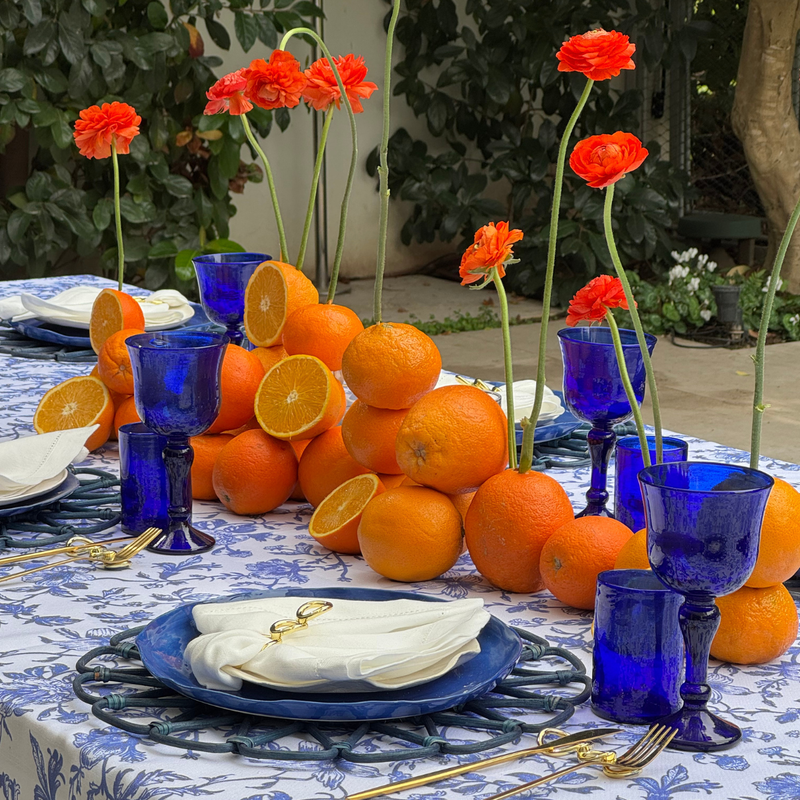 מארז שולחן אירוח להשכרה. קולקציית בוסתן כתום מציעה מארז סטיילינג להשכרה בשילוב כתום רענן, כחול עמוק ולבן קלאסי, ניתן לשלב פירות הדר ופרחים . בסיס מושלם לשולחן קיצי, צבעוני ומלא חיים.
